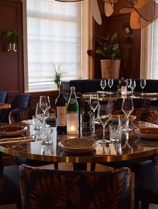 Gedekte ronde tafel in de zaal van Osteria Pomodoro in Lent